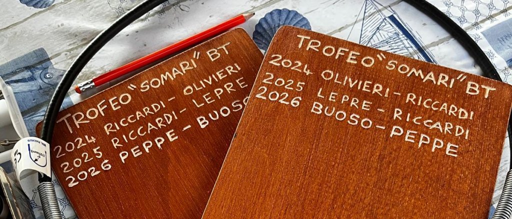 Le incisioni a mano sui due taglieri di legno del Trofeo Somari: i nomi delle coppie arrivate ultime nel 2024, 2025 e 2026