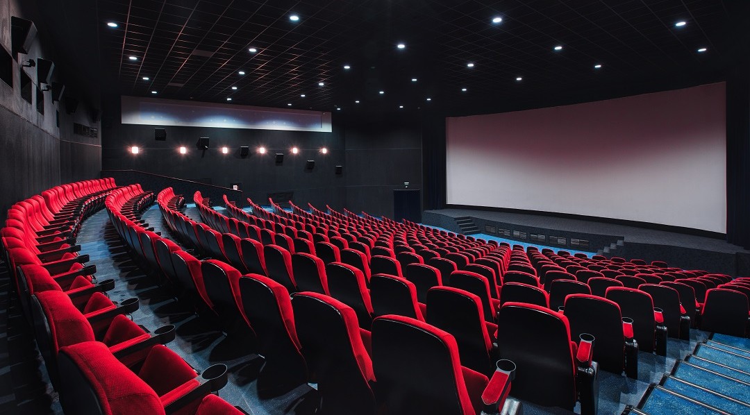 Sala cinematografica moderna con poltrone rosse e schermo